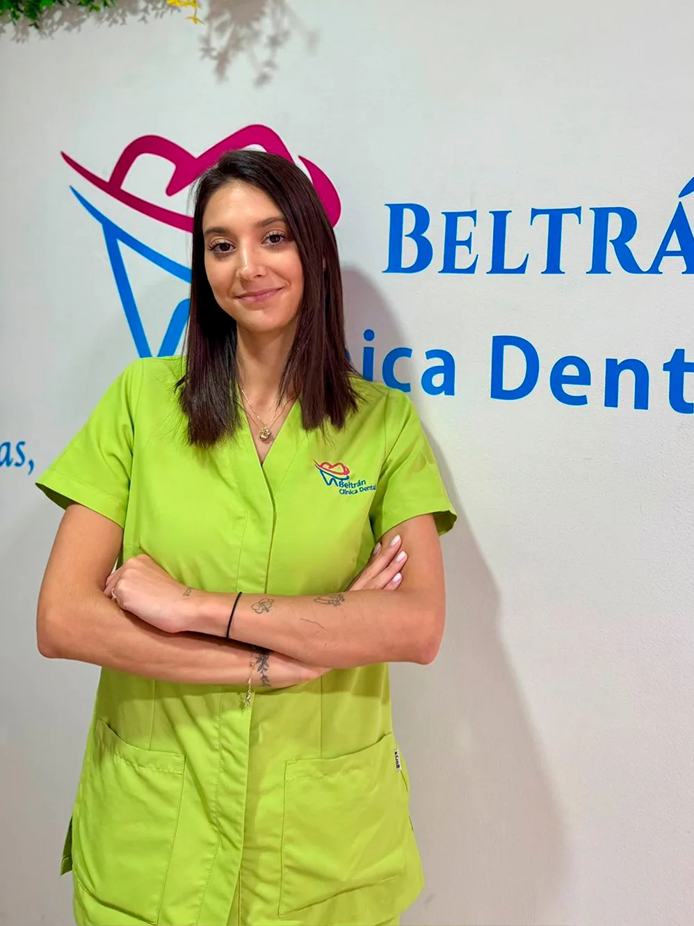 Trabajadora de la clínica con el uniforme verde.